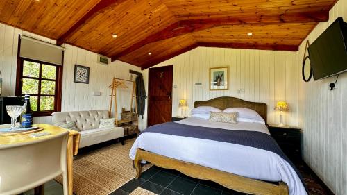 1 dormitorio con 1 cama y 1 sofá en una habitación en The Cider Shed Bed and Breakfast en Wareham