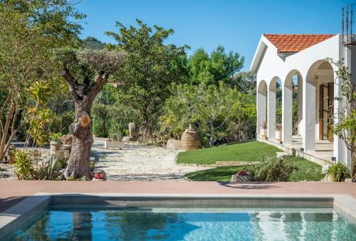 a house with a swimming pool in front of a yard at MyThea Villa by "elite" in Lithakia