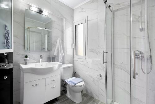 een badkamer met een toilet, een wastafel en een douche bij Kouteris in Lygia