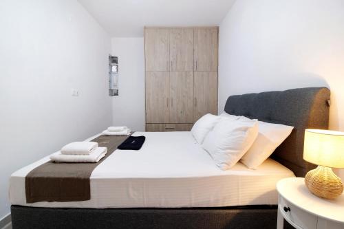 una camera da letto con un letto con asciugamani sopra di Oceanida Sofia Luxury Suite a Nikiana