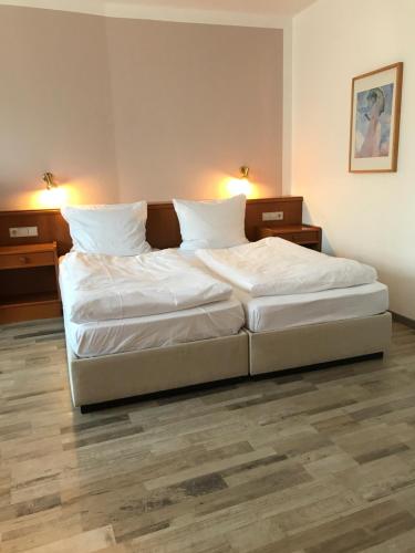 2 Einzelbetten in einem Zimmer mit 2 Lampen in der Unterkunft Hotel Faller in Breitnau
