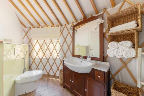 a bathroom with a sink and a toilet and a mirror at L.stile Glamping in Portorož