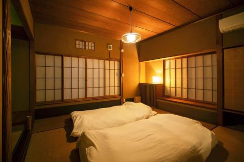 two twin beds in a room with windows at Roopt仙台薬師堂 in Sendai