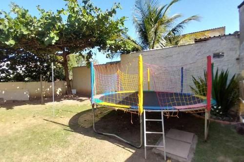 een trampoline met een net in een tuin bij Casa ampla, arejada, muitos jogos e quarto cinema! in Rio das Ostras