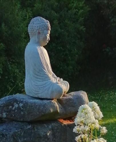 una estatua de una mujer sentada en una roca en Clooncerna Cottage, en Gort