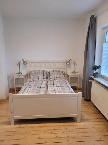 1 cama blanca en una habitación con 2 lámparas en 2 mesas en Ruhige, kleine Unterkunft in Weyhe, Nähe Bremen, en Weyhe