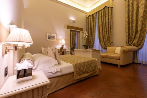 a hotel room with a bed and a chair at Palazzo Guicciardini in Florence