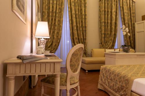 a bedroom with a desk and a bed and a chair at Palazzo Guicciardini in Florence