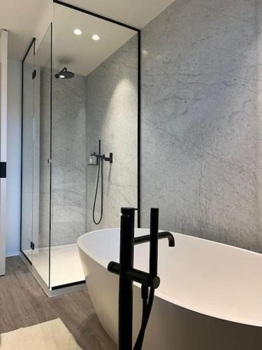 e bagno con vasca e doccia. di Suite Haspengouw a Sint-Truiden