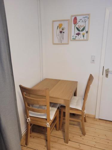 una mesa de madera y sillas en una habitación en Ruhige, kleine Unterkunft in Weyhe, Nähe Bremen en Weyhe