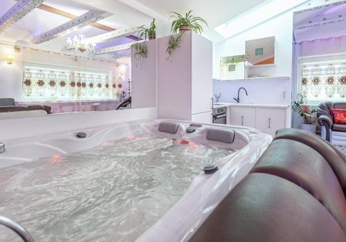 un bagno con ampia vasca riempita d'acqua di President Apartments villa SPA a Vilnius