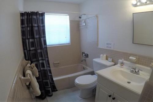 a bathroom with a toilet and a tub and a sink at Beach Resort in Cape Coral in Cape Coral