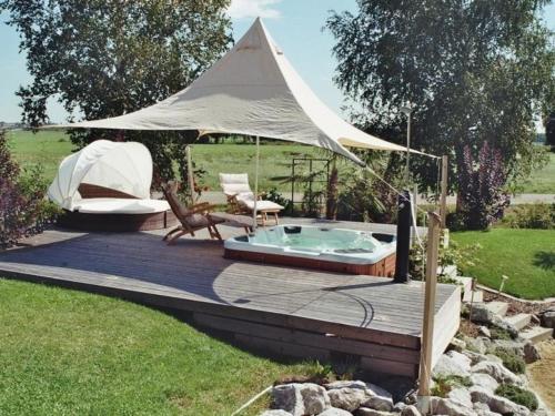 een terras met een hot tub en een tent bij Ferienwohnung für Nichtraucher am Ortsrand mit Balkon, 4 Sterne DTV Klassifizierung in Bad Buchau