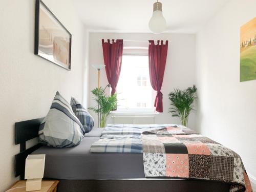 een bed in een slaapkamer met rode gordijnen bij Citywohnung mit Gartenzugang in Schwerin