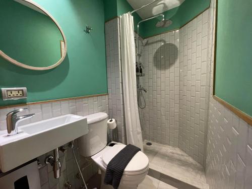 een badkamer met een toilet, een wastafel en een douche bij The Palette Bangkok Hotel in Bangkok