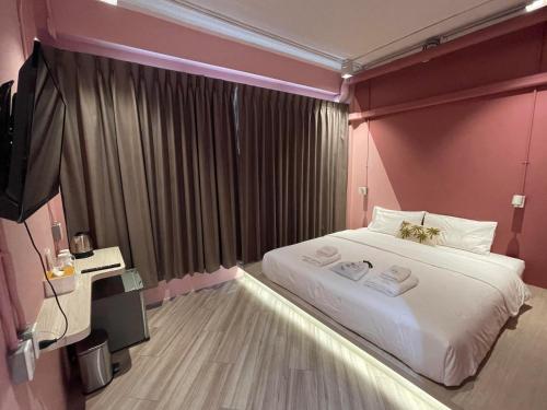 a bedroom with a large bed with two towels on it at The Palette Bangkok Hotel in Bangkok