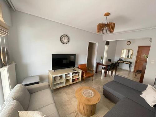 ein Wohnzimmer mit einem Sofa und einem Flachbild-TV in der Unterkunft Alexandra's View in Piräus