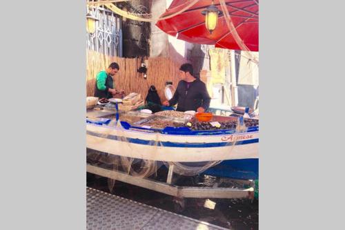 un grupo de personas preparando comida en un barco en Milonghita Camera con bagno vista mare centro storico, en Siracusa