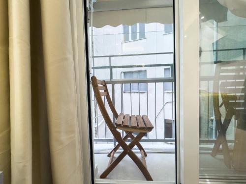 una silla de madera sentada en un balcón junto a una ventana en Athens Luxury Penthouse, en Atenas