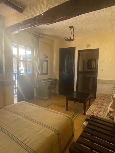 a bedroom with two beds and a desk at Riad Al Madina in Essaouira