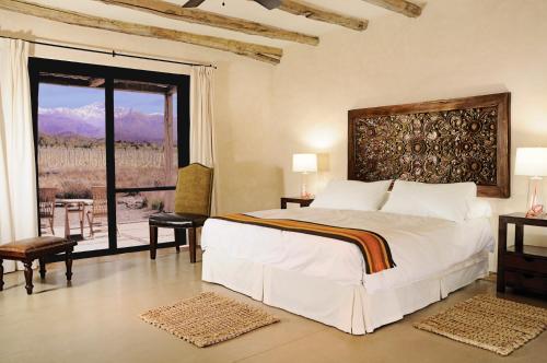 a bedroom with a large bed and a large window at Bodega Alpasión Lodge y Glamping in Tunuyán