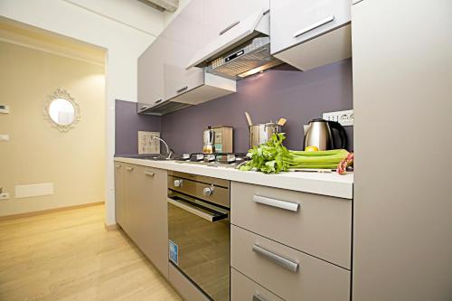 a kitchen with stainless steel appliances and vegetables on the counter at Residenza Il Cavaliere del Lago - Happy Rentals in Riva del Garda