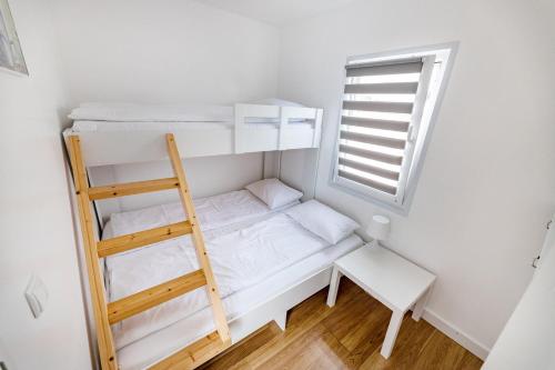 a small room with a bunk bed and a ladder at Fantazja Resort Zator in Zator