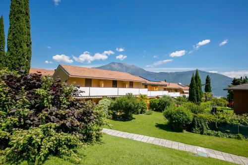 a house with a garden and mountains in the background at Residence Christina Due Laghi in Tenno