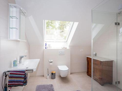 een badkamer met een wastafel, een toilet en een raam bij at the weir Modern retreat in Allersberg
