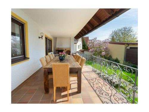 a wooden table and chairs on a balcony at am Wehr Comfortable holiday residence in Allersberg