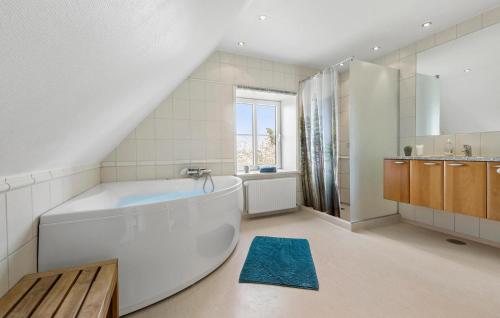 La grande salle de bains est pourvue d'une baignoire et d'un lavabo. dans l'établissement Pet Friendly Home In Rnde With Kitchen, à Rønde