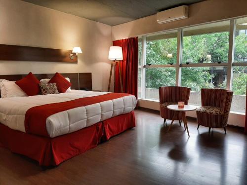 a bedroom with a bed and a table and chairs at First Palermo Hotel in Buenos Aires