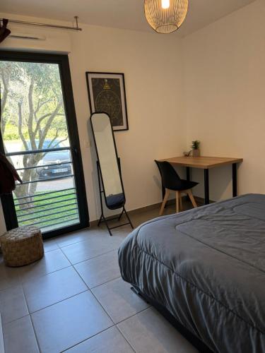 une chambre avec un lit, une table et une fenêtre dans l'établissement Charmant T2 idéalement situé, à Bastia