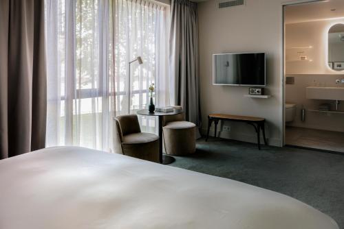 um quarto de hotel com uma cama e uma grande janela em Pillows Luxury Boutique Hotel aan de IJssel em Deventer