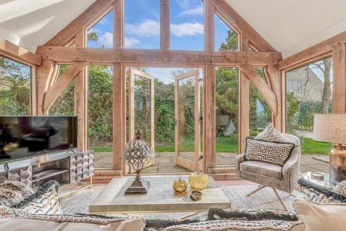 a living room with a large room with glass windows at Hiron's Piece - Hot Tub Packages Available in Weston Subedge