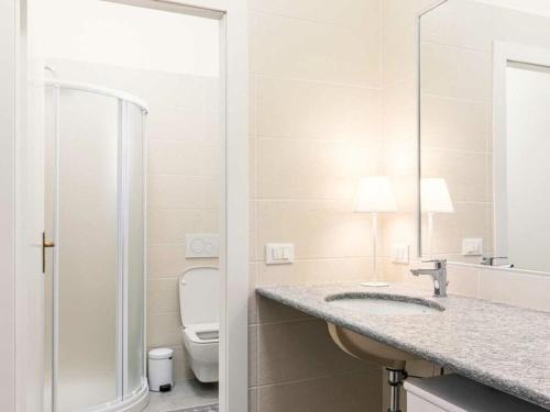 La salle de bains blanche est pourvue d'un lavabo et de toilettes. dans l'établissement Palazzo Barbò Modern retreat, à Pumenengo