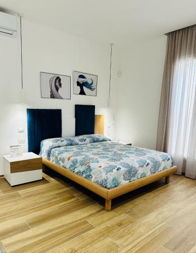 um quarto com uma cama com um edredão azul em Mister Flamingo em Torre Colimena