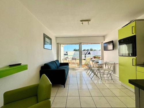un salon avec un canapé et une cuisine avec une table dans l'établissement Appartement T2+Cabine à Carnac, Balcon Sud, Proche Plages, 4 Pers. - FR-1-377-29, à Carnac