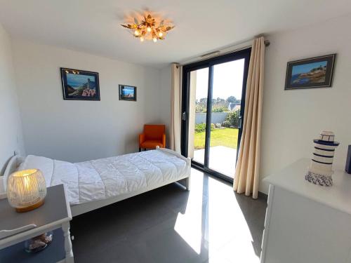 une chambre d'hôpital avec un lit et une porte coulissante en verre dans l'établissement Maison neuve 4* avec Sauna, WIFI à 150m de la plage - Pleumeur-Bodou - FR-1-368-139, à Pleumeur-Bodou
