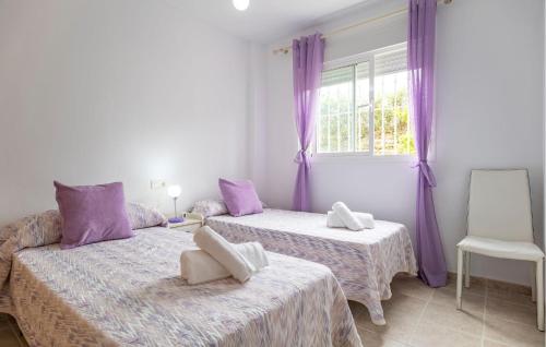 duas camas num quarto com cortinas roxas e uma janela em Amazing Apartment In Casares With Kitchenette em Casares