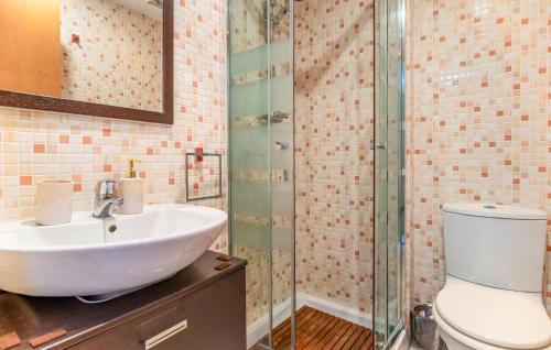 uma casa de banho com um lavatório e uma cabina de duche em vidro. em Amazing Apartment In Casares With Kitchenette em Casares