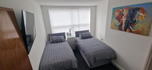 a room with two beds in front of a window at 8 Guest : 6 Bed : Whole House : Anfield : Parking in Liverpool