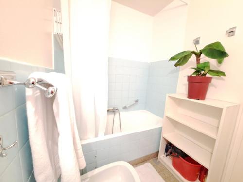La salle de bains est pourvue de toilettes, d'une baignoire et d'une plante. dans l'établissement Studio à Pra Loup 1600 pour 6 pers, proche pistes - FR-1-165A-74, à Uvernet