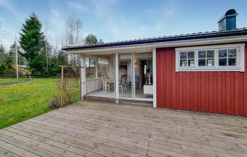 a red house with a deck in a yard at 3 Bedroom Pet Friendly Home In Källby in Källby