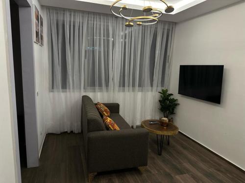 a living room with a couch and a television at Bark Luxury Appartments @Signal Abidjan Plateau in Abidjan
