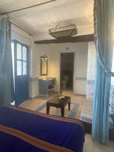 a living room with a bed and a table at Riad Al Madina in Essaouira