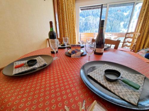 - une table avec une bouteille de vin et des verres dans l'établissement Studio Cabine Cosy à Praloup avec Balcon - FR-1-165A-80, à Uvernet