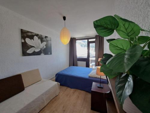 a living room with a bed and a potted plant at Appartement T3 cosy pour 8 pers. à Pra-Loup, à 50m des pistes avec balcon et parking privé - FR-1-165A-78 in Uvernet-Fours