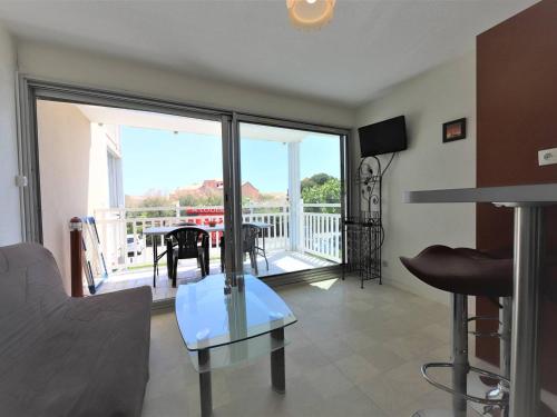 un salon avec une table en verre et un balcon dans l'établissement Beau 2 pièces pour 5 pers. avec parking, piscine et loggia, à 400m de la plage à Palavas - FR-1-559-14, à Palavas-les-Flots