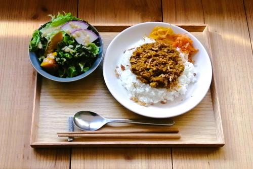 a plate of rice and a bowl of salad and a spoon at Ten to Sen Guesthouse in Takamatsu